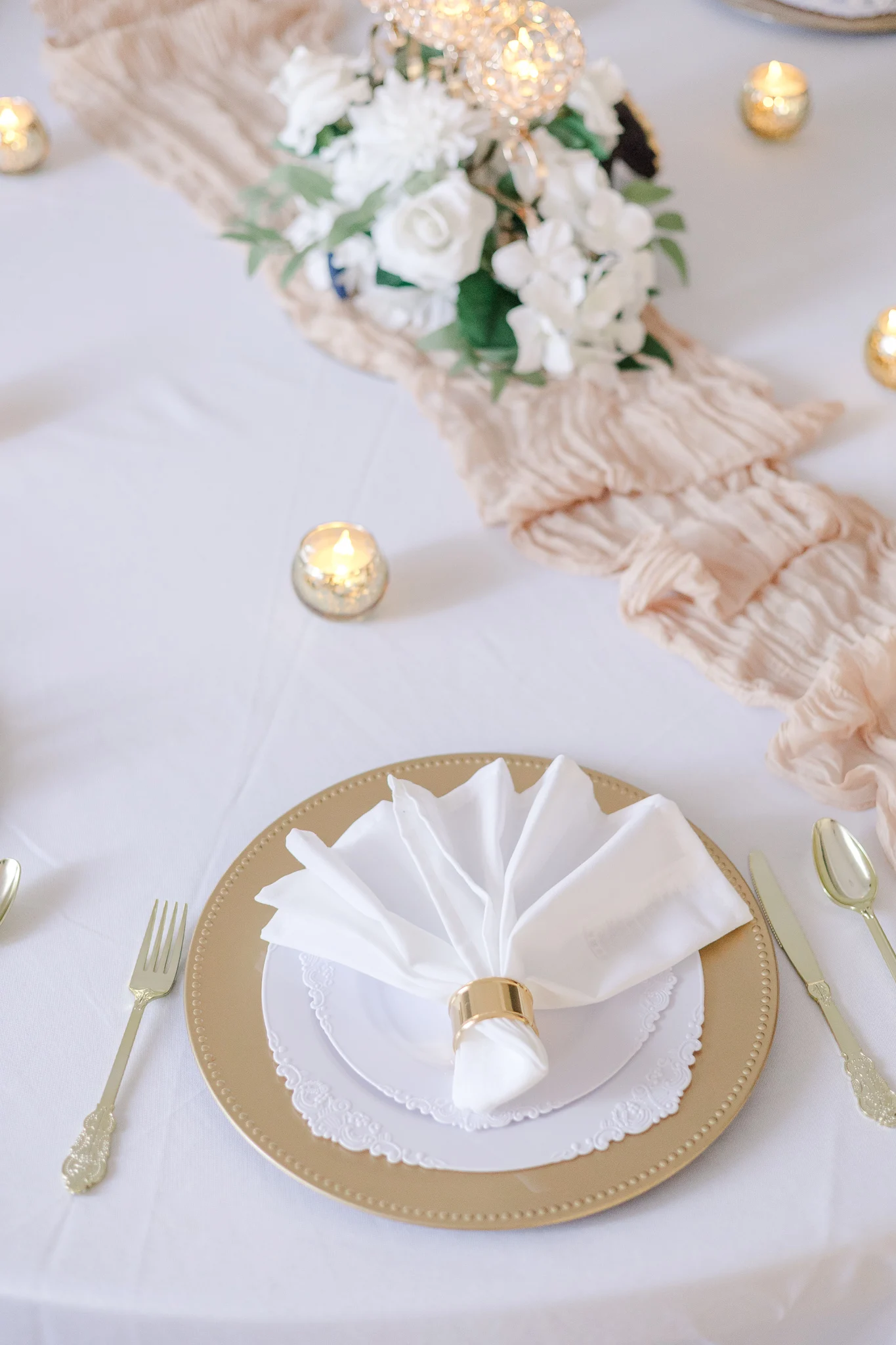 Gold-rimmed place setting with a white floral centerpiece